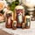 Matriochka russe traditionnelle représentant cinq chats roux, gris et noirs, peints à la main et vernis, présentée en gros plan sur un élégant fond décoratif avec des fleurs et des éléments d’intérieur légèrement floutés