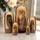 Five owl Russian nesting dolls displayed in a bright elegant interior, featuring different hand-painted owl designs, 18 cm collectible Matryoshka set with glossy lacquer finish