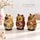 Three hand-painted owl nesting dolls displayed side by side, featuring distinctive cream, red and brown designs with smaller owls painted on their bodies, in a decorative home setting.