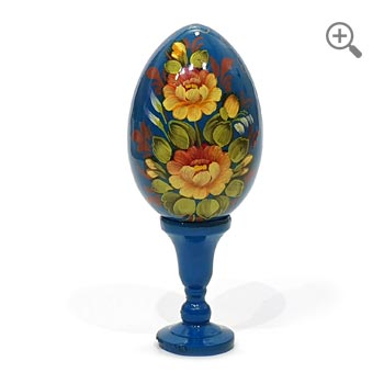 Œuf de Pâques bleu peint à la main avec motif floral en style russe Zhostovo, bois laqué brillant avec décor doré, présenté sur support et fond blanc épuré