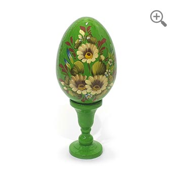 Œuf de Pâques en bois à fond vert brillant avec marguerites peintes à la main, décoration artisanale en style russe avec motifs dorés, présenté sur socle et fond blanc