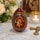 Wooden Orthodox Easter egg with the Our Lady of Zhirovitsy icon displayed beside a candle and cross in a devotional setting.